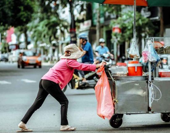 Creo: La Nueva Alternativa de Crédito del Gobierno para Desafiar al 'Gota a Gota - Vendedora ambulante empujando carrito en la calle.