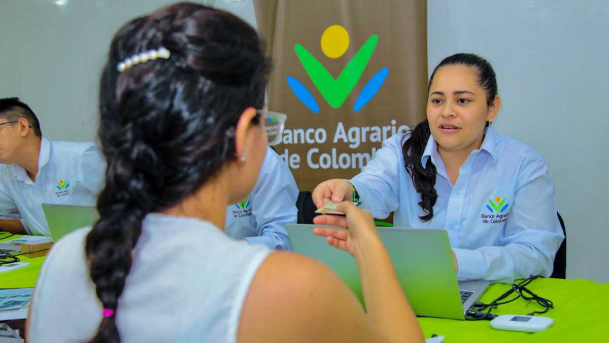 Funcionaria del Banco Agrario de Colombia, pagando el 5 ciclo a beneficiaria.
