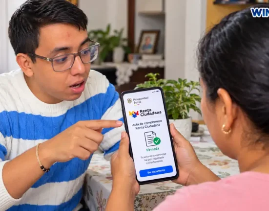 Madre consulta el acta de compromiso de Renta Ciudadana en su celular mientras recibe orientación.