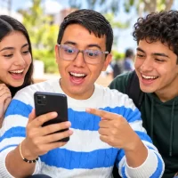 Jóvenes consultan en un celular el abono a cuenta bancaria del quinto ciclo de Renta Joven 2026.