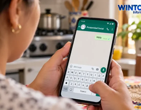 Mujer sostiene un celular con un chat ilustrativo de Prosperidad Social en una cocina.