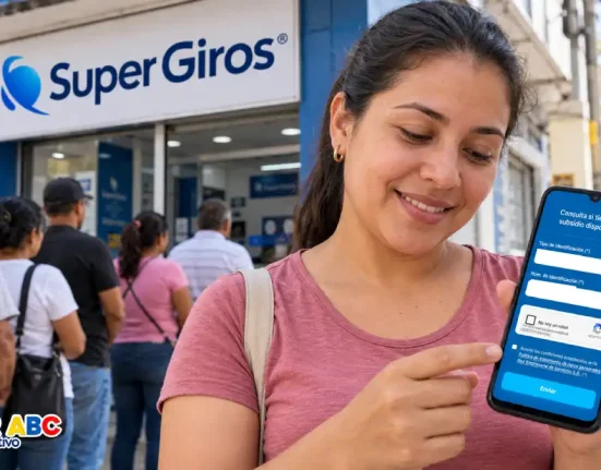 Mujer consultando SuperGIROS en un celular, con personas haciendo fila al fondo.