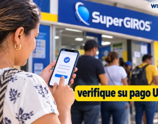 Mujer consulta en su celular el pago de la UNGRD frente a un punto de SuperGIROS.