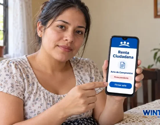 Madre muestra un celular con una representación del mensaje de firma pendiente del acta de Renta Ciudadana.