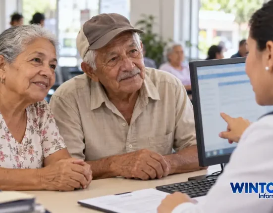 Dos adultos mayores reciben orientación de una funcionaria en una oficina de atención.