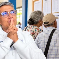 Wintor ABC envejecido junto a adultos mayores que revisan avisos en una oficina municipal.