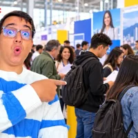 Personas con hojas de vida durante una feria de empleo en Bogotá.