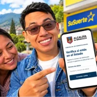 Wintor ABC muestra en un celular la consulta por cédula para damnificados en Manizales, Caldas, acompañado de una madre y su hija.